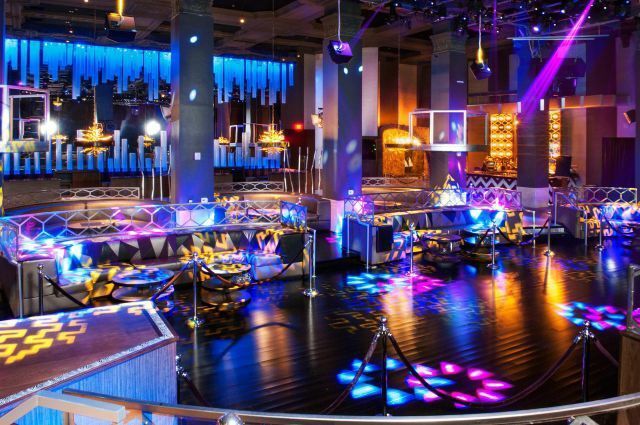 A vibrant and colorful interior scene, an entertainment venue, with various illuminated structures and bright lights creating a dynamic atmosphere at the Friday Elevation at PARQ San Diego
