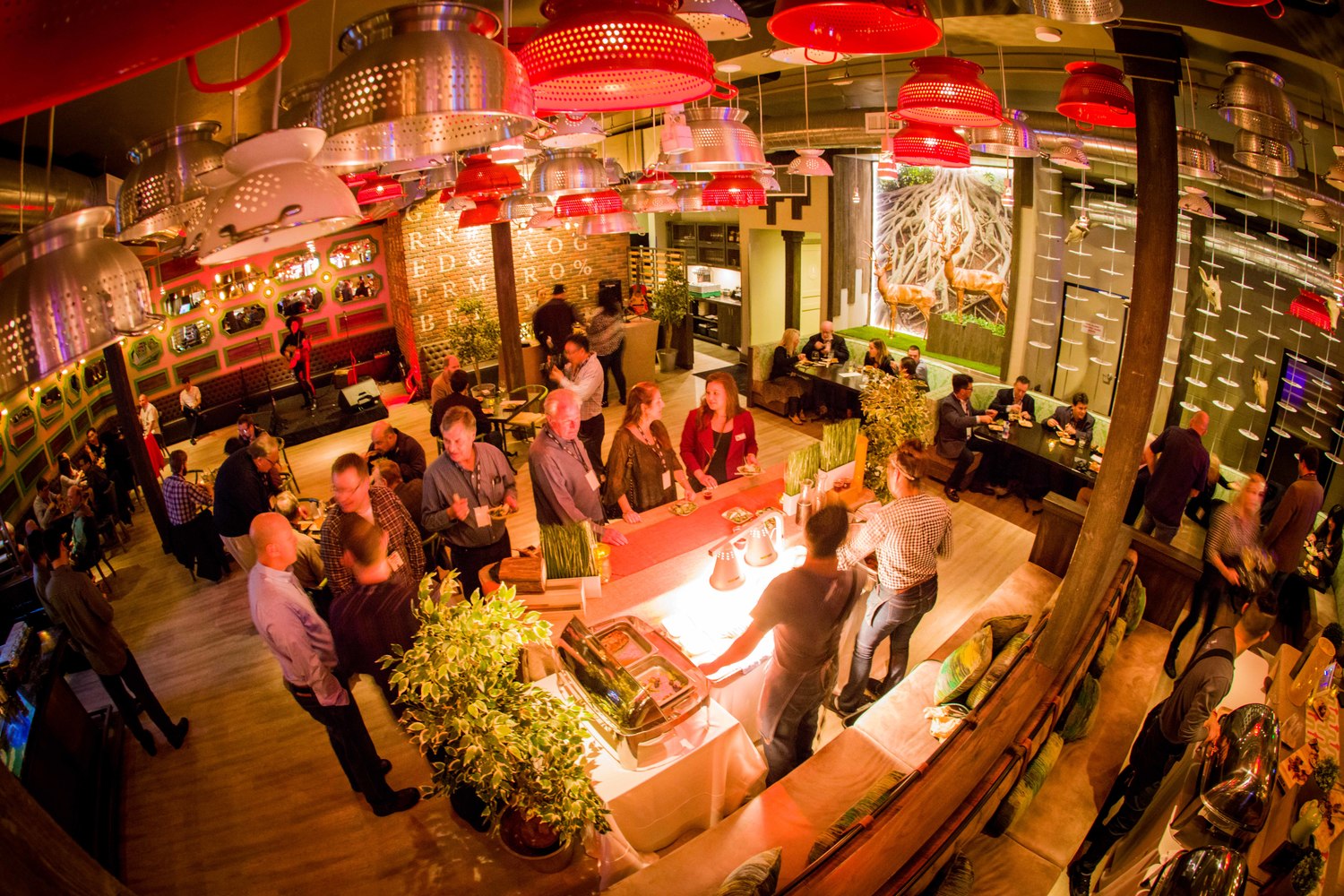 A warm-toned image depicting a crowded indoor space, possibly a market or event, with many people and various items, suggesting a lively atmosphere at Rustic Root Rooftop Fridays